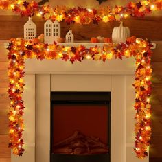 a fireplace decorated with fall leaves and pumpkins