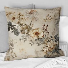 a pillow with flowers on it sitting on top of a bed