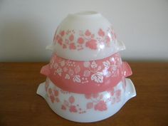 three bowls stacked on top of each other with pink and white flowers painted on them