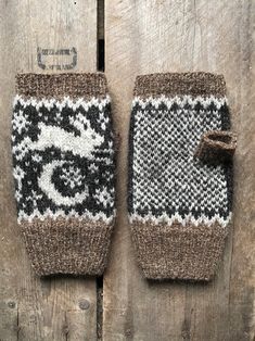 two knitted mitts sitting on top of a wooden table