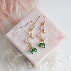 "Emerald Green Flower Earrings // Gold Filled Earrings // Boho Bridal Earrings // Floral Earrings // May Birthstone // Leaf Earrings // Birthday Gift // Bridesmaids Earrings // Four Leaf Clovers  :: Provide an enchanting effect with these lush emerald green floral earring for your woodland wedding :: These emerald green flower earrings are a delicate and feminine design perfect for any boho wedding attire or for adding a little sparkle to your next special occasion. The tiny verdant flower petals are created with faceted glass and are reminiscent to four leaf clovers. These dainty flowers are secured to golden stems featuring small cubic zirconia leaves. The lush green flower earrings are light weight and suspended from comfortable 14k gold filled earrings.  Whether adding these flower ear Green Flower-shaped Jewelry For Anniversary, Green Flower-shaped Anniversary Jewelry, Green Flower Shaped Anniversary Jewelry, Crystal Earrings For May Birthstone Gift, Green Flower Shaped Jewelry For Wedding, Delicate Dangle Jewelry With Flower Decoration, Delicate Green Jewelry With Birth Flower, Delicate Jewelry With Matching Earrings For Celebration, Elegant Green Earrings For Mother's Day