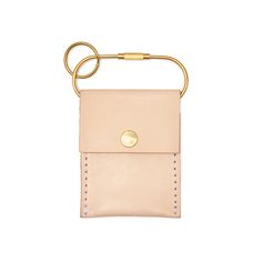 a small pink leather case with a gold ring on the front and an empty card holder in the back