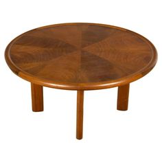 a round wooden table with four legs and an octagonal design on the top, against a white background