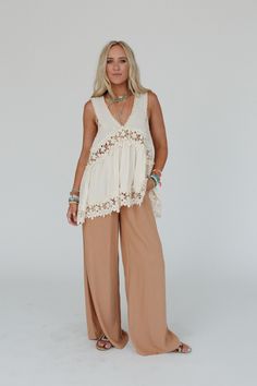 Fun, flowy, and unique—every boho gal's dream! The Catania Lace Trim Tunic Top is exactly what you've been looking for. Don't miss out! So pretty, intricate crochet fabric and contrast details throughout Relaxed and loose tank top silhouette Classic V - neckline and sleeveless design with thick tank straps Low V - backline with classic zipper back closure for comfortable fit Slight high - low crochet trim bottom edge with a rounded back edge for added boho style Pair with: Evermore Seamless Lace Bohemian Lace Top For Spring, Spring Bohemian Embroidered Lace Top, White Bohemian Crochet Top With Lace Trim, Sleeveless Cotton Lace Top With Crochet Trim, Bohemian Lace Crochet Top For Vacation, Bohemian V-neck Top With Lace Patchwork, Bohemian Lace Top For Beach In Spring, Bohemian V-neck Tops With Lace Patchwork, Beige Lace Top For Beach