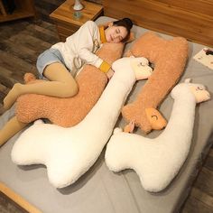 a woman laying on top of a bed covered in giant stuffed animals