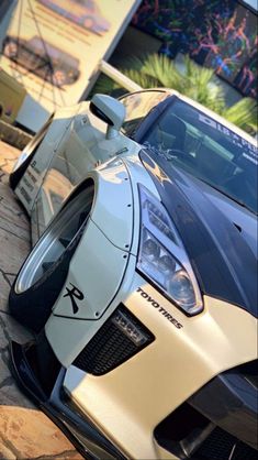 a white and black sports car parked in front of a building