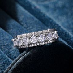 a diamond ring sitting on top of a blue velvet surface with diamonds in it's center