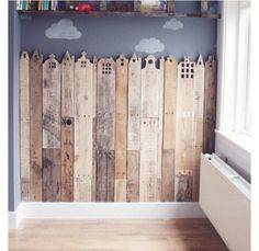 a wooden fence with clouds painted on the wall and behind it is a radiator