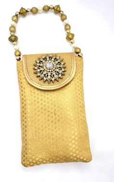 Product Description Mobile pouch style handbags with beaded string Great for holding mobile with your ethnic wear while enjoying the occasion. Back of the bag has a zipped pocket for additional space to hold cards Dimensions: 7" x 4.5" Weight: ~ 3 Oz each Material: Raw silk fabric Design: HBG#191 Gold Rectangular Shoulder Bag With Cell Phone Pocket, Gold Pouch Shoulder Bag With Cell Phone Pocket, Gold Bag With Cell Phone Pocket For Gift, Gold Bags With Cell Phone Pocket For Gift, Gold Shoulder Bag With Latkans In Pouch Shape, Gold Pouch With Latkans For Festivals, Gold Pouch Phone Bag For Daily Use, Gold Rectangular Phone Bag With Cell Phone Pocket, Gold Rectangular Phone Bag Gift