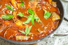 a pan filled with meat and vegetables covered in sauce