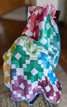 a multicolored quilt sitting on top of a chair