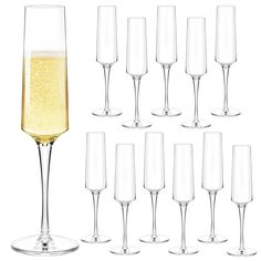 there are many wine glasses and one is filled with white wine, the other has champagne in it