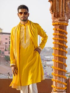 SHRESTHA BY VASTRAMAY Men's Yellow Silk Machine Embroidered Kurta Luxuriate in this vibrant yellow kurta, featuring intricate machine embroidery. Made from a silk blend, this kurta boasts a comfortable and stylish fit. Pair it with a dhoti or pajamas for a complete traditional look. Key Features Yellow silk blend with machine embroidery Mandarin collar Long sleeves Side slits Pockets Specifications Sleeve Length: Full Sleeves Top Shape: Straight Top Hemline: Straight Top Length: Knee Length Mate Festive Yellow Kurta With Intricate Embroidery, Yellow Chanderi Traditional Wear With Intricate Embroidery, Yellow Embroidered Kurta For Diwali, Festive Yellow Kurta With Zari Work, Yellow Straight Kurta For Festivals, Yellow Kurta With Chikankari Embroidery For Diwali, Yellow Straight Kurta For Festive Season, Festive Yellow Kurta With Chikankari Embroidery, Yellow Traditional Wear With Gold Embroidery For Festivals