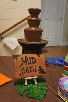 there is a sign that says mud bath on the table next to some plates and cups