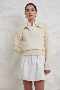 A soft and comfortable sweater to take you through the seasons. The breathable knit fabric means you can wear this ivory sweater on its own with shorts during warmer months, or you can layer it and style it with your favorite trousers when it's cold. A classic silhouette, you can pair this sweater with all of your favorite bottoms. For a comfortable and casual look, wear this sweater with some high-waisted jeans and your favorite sneakers. Knit Collar Drop shoulder V neckline Long sleeves Ribbed Ivy Clothing, Faux Shearling Jacket, English Factory, Casual Party Dresses, Knit Outerwear, Ivory Sweater, Balloon Sleeve Blouse, Comfortable Sweater, Soft Classic