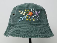 a green hat with embroidered flowers on it