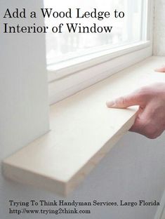 someone is holding onto the edge of a window sill