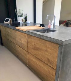 a kitchen counter top with a sink and wooden cabinets in front of the countertop