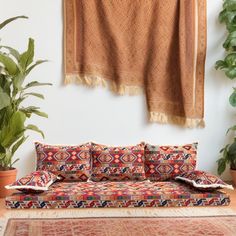 a couch sitting in front of a potted plant