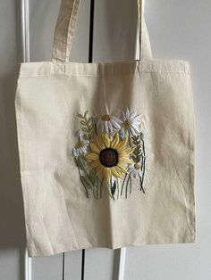 a tote bag with flowers on it hanging from a door