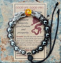 "Introducing the GOOD LIFE/GOOD VIBES bracelet! A bracelet that is beautiful and meaningful.    SYMBOLIC MEANING OF THIS BRACELET: 🔥 Dragon are symbols of prosperity, success and good luck.   The positive energy from this bracelet helps you LIVE YOUR BEST LIFE! This POWERFUL bracelet:   👍 Features silver dragon head beads, with matching hematite spacer beads, 👍 🔥 FIRE DRAGON (red & yellow central bead)  👍 Has 10mm Silver and Grey Hematite Beads, 👍 Is made with durable memory wire so that t Spiritual Charm Bracelet With 8mm Beads As A Gift, Spiritual Charm Bracelet Gift, Spiritual Nickel-free Beaded Bracelets As A Gift, Nickel Free Spiritual Beaded Bracelets As Gift, Nickel-free Spiritual Beaded Bracelets Gift, Spiritual Hematite Bracelet Jewelry, Spiritual Hypoallergenic Charm Bracelet As Gift, Spiritual Silver Crystal Bracelet For Friendship, Silver Spiritual Crystal Bracelet For Friendship