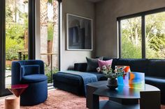 a living room filled with furniture and large windows