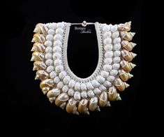 a necklace made out of shells on a black background