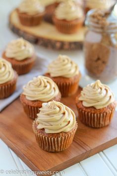 cupcakes with frosting sitting on a cutting board