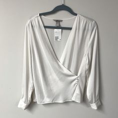 Pretty Off-White Wrap Blouse. It Ties On The Inside And Then Buttons On The Outside. Would Look Cute In The Summer With A Pair Of Jeans. New With Tags. Would Best Fit A Medium, See Measurements Below. Measurements (Laid Flat) Waist: Approx 18 In. (When Buttoned Closed) Pit To Pit: 19.4 (When Buttoned Closed) Length: 24 In Tag Size: Medium H&m Long Sleeve Tops For Work, White Long Sleeve Top From H&m, H&m White Long Sleeve Top, H&m V-neck Tops For Day Out, Elegant H&m Shirt For Spring, Chic H&m Shirt For Summer, Elegant H&m Tops For Day Out, H&m V-neck Blouse For Spring, H&m White Blouse For Spring