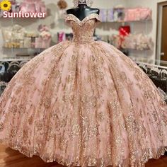 a pink ball gown with gold sequins is on display in a store window