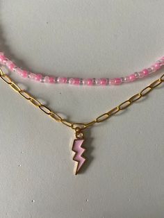 comes with a pink beaded necklace and a pink lightning bolt on a gold chain. SUPER CUTE!! can go together or separate. Pink Lightning Bolt, Pink Lightning, Pink Beaded Necklace, Lightning Bolt Necklace, Lighting Bolt, Necklace Stack, Pink Beaded, Pink Necklace, Lightning Bolt