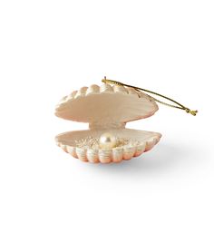 an open shell with pearls on it and a gold stick sticking out of the shell