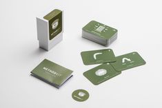 four green business cards sitting on top of each other next to a white card holder