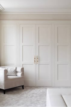 an empty room with white furniture and large closets on the wall, along with a couch