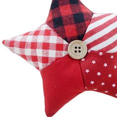 a red and white plaid star pillow with a button on the side, sitting against a white background