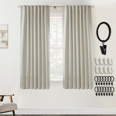 the curtains are hanging on the wall in front of the window with hooks and scissors