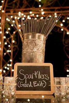 a chalkboard sign that says sparklers grand exit next to some glasses with straws in them