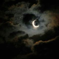 the moon is partially obscured by dark clouds