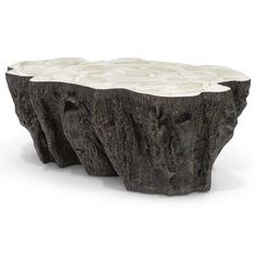 a table made out of wood with white marble on the top and bottom, as if it were carved from an old tree trunk