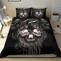 a bed with a black comforter and two skulls on it, all covered in white sheets