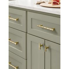 a kitchen with gray cabinets and gold handles