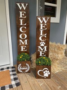 two wooden welcome signs sitting next to each other on top of a wood floor near hay bales