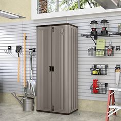 a large metal storage cabinet next to a wall with hooks and tools on it in a garage