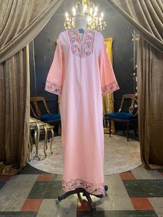 "Vintage 1970s kaftan 70s maxi dress Peach cotton V-neck Bell sleeves Swirling rainbow embroidery on the bib, cuffs and hem Zips up the back Very good vintage condition Size medium Bust 36/38\" Hips best to 43\" Length 51\"" Pink Floor-length Kaftan For Spring, Pink Floor-length Spring Kaftan, Embroidered Maxi Length Pink Kaftan, Pink Embroidered Maxi-length Kaftan, Embroidered Pink Maxi Kaftan, Pink Embroidered Maxi Length Kaftan, Pink Embroidered Maxi Kaftan, Spring Pink Embroidered Kaftan, Pink Embroidered Long Sleeve Maxi Dress