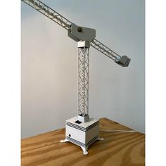 a white table with a light on top of it and a crane in the background