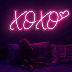 a neon sign that says xoxo on it in front of a purple background