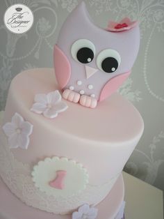 a pink and white cake with an owl on top