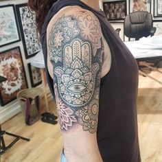 a woman with a hamsa tattoo on her arm