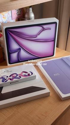 two new ipads are sitting on a table next to each other, one is purple and the other is white