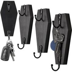 four pieces of black and gray luggage with keys hanging from hooks